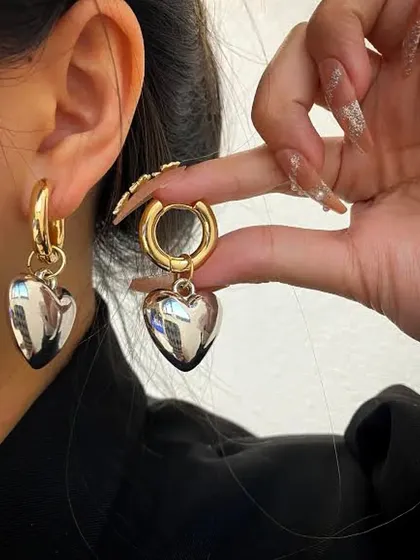 A model shot showing how the 18k gold-plated heart earrings look when worn.