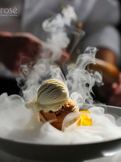 Dessert is not just a course; it's a grand finale. This dramatic presentation, featuring scoops of ice cream enveloped in a cloud of dry ice, exemplifies the gourmet artistry and theatrical flair we bring to our sweet creations.