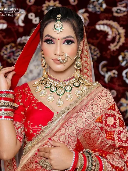 The complete traditional bridal look with a red saree and heavy jewelry. You will learn to balance heavy attire with makeup that enhances, not overwhelms.