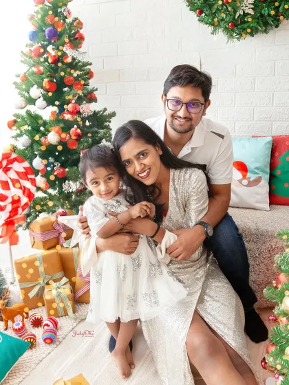 Love is all around this beautiful family during their Christmas photoshoot. The decorated trees and cozy setting create a magical holiday atmosphere.
