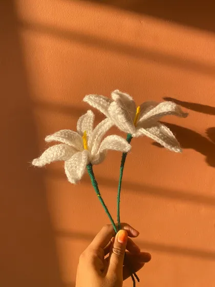 Two beautiful handmade white lilies, glowing in the sunlight. Their simplicity and elegance make them a timeless choice.