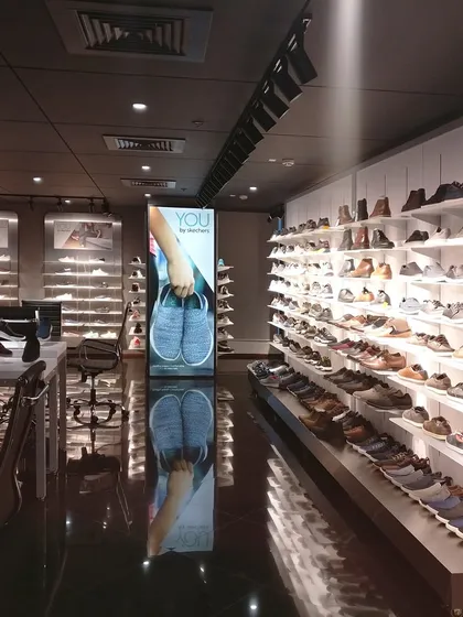 For the Skechers workspace and showroom, the design needed to align with the brand's energetic vision. This area features extensive, brightly lit shelving to showcase the product line effectively.