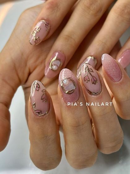 Soft yet detailed. These bridal extensions feature a shimmery pink base with delicate gold chrome outlines of flowers and a central pearl accent.