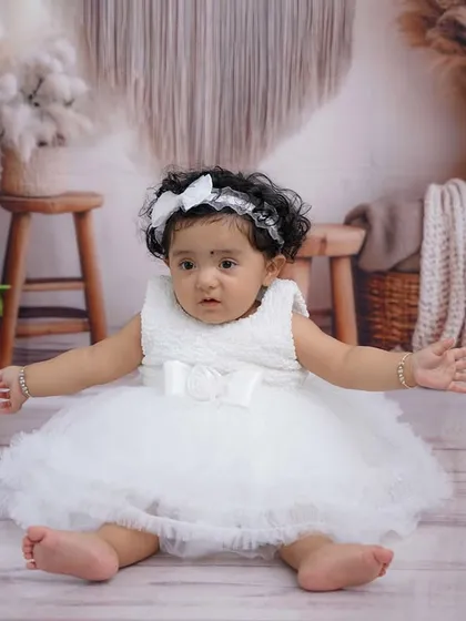 A change of outfit to a lovely white dress, showing the versatility within a single boho-themed first birthday session.
