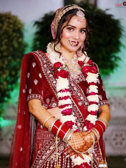 A portrait of a bride after the varmala ceremony, with the garland adding to her beautiful wedding look.