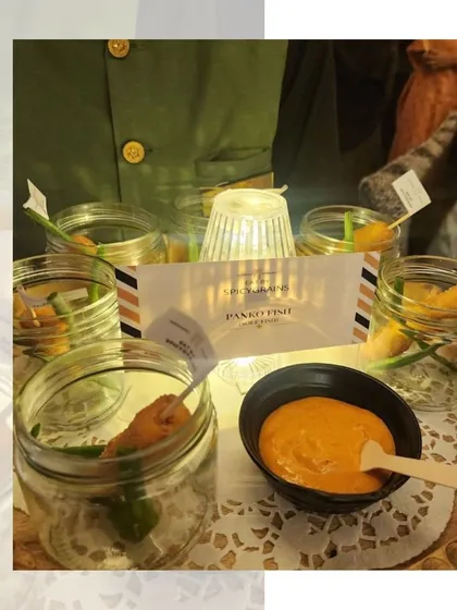 Crispy Panko Fish bites served in individual jars with a dipping sauce. This is a stylish and modern way to serve a classic fried fish appetizer.