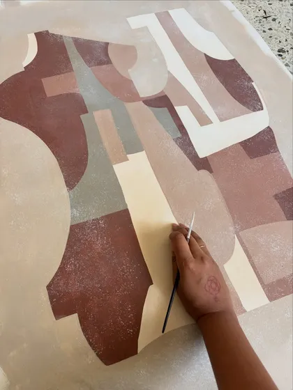 Painting abstract shapes in earthy tones. This is a meditative process where my hands follow the flow, letting the composition emerge organically.