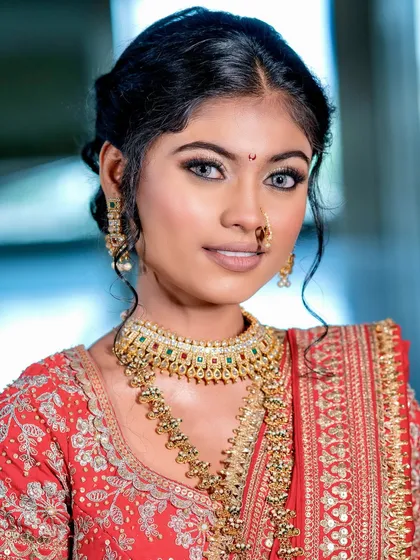 A striking portrait. The makeup enhances her beautiful features, with a muted nude lip balancing the bold, traditional attire.