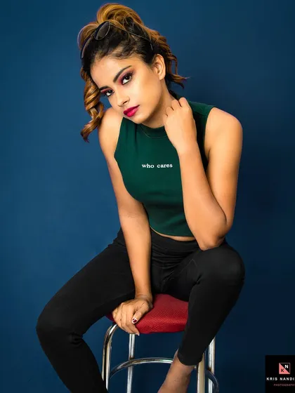 Attitude is everything. This studio shot uses a bold blue background and a confident pose to create a high-energy fashion portrait. The "who cares" on the top speaks volumes, capturing a rebellious and carefree spirit.