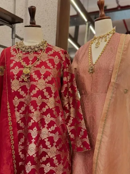 A classic red Banarasi brocade suit, paired with a simpler peach-colored suit. This shows how I curate pieces that can be worn together for a coordinated family look.