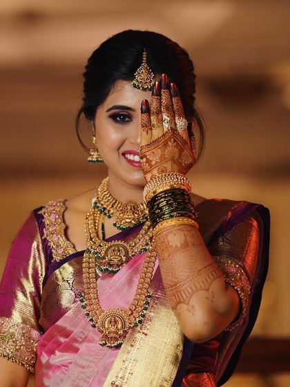 A classic peek-a-boo pose from a smiling bride, showing off her intricate palm design.