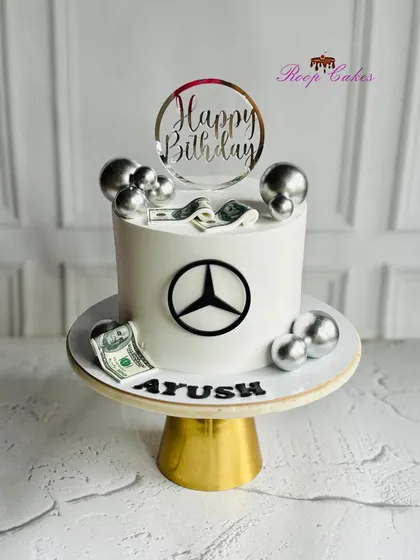 A classy cake for a classy celebration. This Mercedes-themed cake is perfect for a car lover, featuring the iconic logo and silver accents.