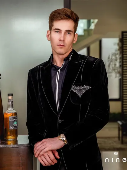 This black velvet blazer from our 'Metal Bling' collection features subtle piping and a bat-wing pocket crest, adding a touch of dark elegance.