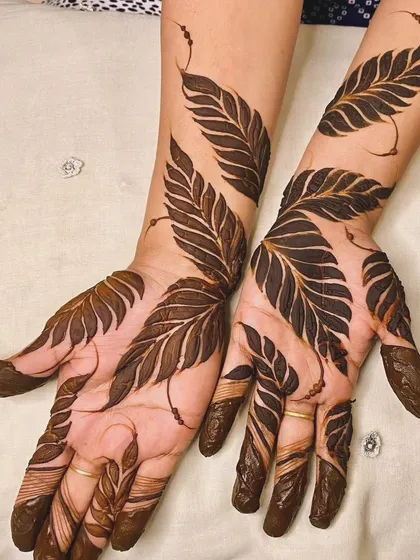 For those who love a bold and modern look, this Gulf-style leaf pattern is perfect. The design uses negative space to make the large, shaded leaves pop, creating a striking and elegant statement on the hands and arms. 🌿