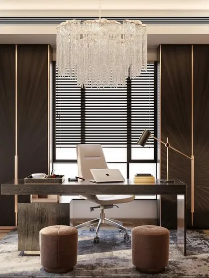 In this executive cabin, we used a dark, luxurious palette with rich wood paneling and a statement crystal chandelier to convey authority and elegance. The space planning includes built-in storage and a clear distinction between the work desk and a small, informal meeting area.