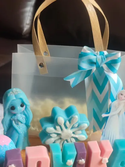A close-up of the items in the "Frozen" gift bag, including the glittery Elsa soap and custom name soaps.