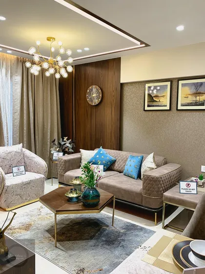 A look at a sample flat we designed, featuring a cozy living room setup. The space is defined by a warm color palette, quilted upholstery with gold accents, and carefully selected art and decor.
