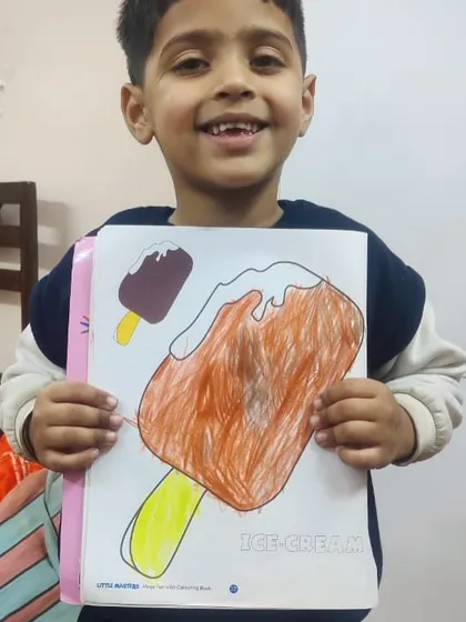 A young artist happily presents his large drawing of a chocolate ice cream bar. His enthusiasm is as delightful as his artwork.