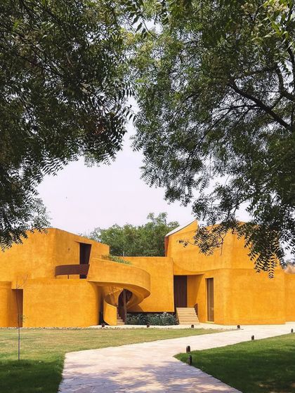 Framed by two trees, the building appears as a hidden gem discovered within the forest.