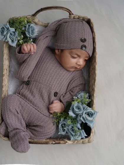 Using simple, natural props like this woven basket helps to highlight the smallness and innocence of your newborn. This little one is sleeping soundly in a cozy, buttoned outfit.