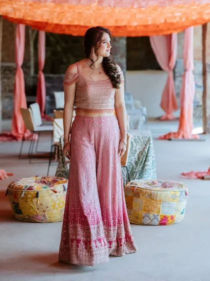 A portrait of the bride in her beautiful pink Mehendi outfit, set against the rustic decor of Fort Neemrana.