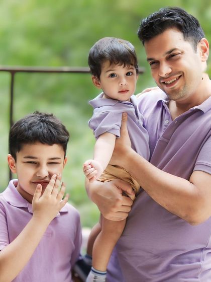 A moment of pure, unscripted fun during our family session. The older son's playful giggle adds a touch of authentic joy to this father and sons portrait.