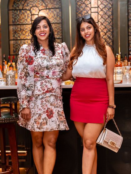 Two friends pose by the bar, dressed in their Sunday best for a day of food and fun at Roxie.