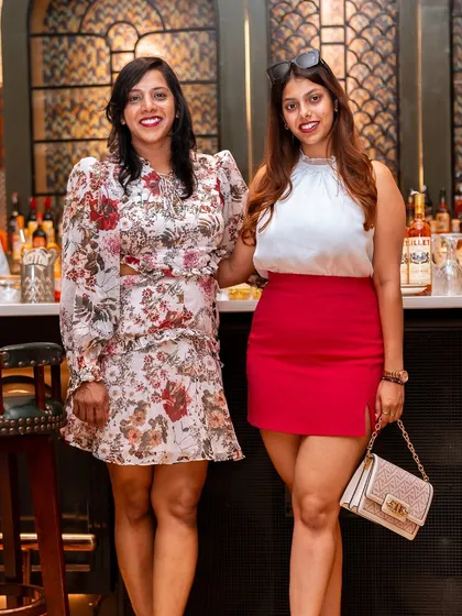 Two friends pose by the bar, dressed in their Sunday best for a day of food and fun at Roxie.