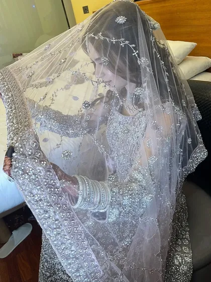 A beautiful, candid shot of the bride under her delicate, embellished veil. This captures a quiet, intimate moment before her reception.