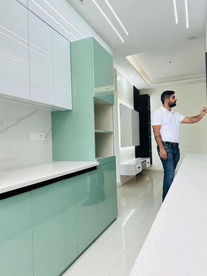 Another angle of the mint green kitchen, showing the TV unit on the other side, demonstrating how we design cohesive open-plan living spaces.