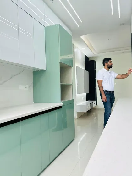 Another angle of the mint green kitchen, showing the TV unit on the other side, demonstrating how we design cohesive open-plan living spaces.