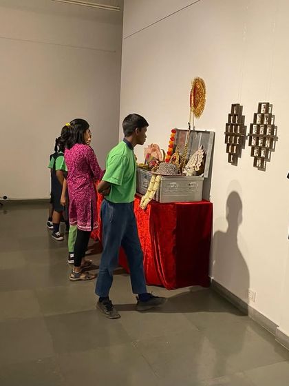 Students curiously inspecting the trunk of costumes and props available for the interactive photo session.