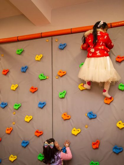 On the way to the top! Our padded rock climbing wall offers a safe challenge for little climbers, with holds of all shapes and colors.