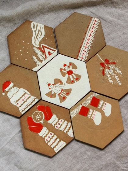 A closer look at the hand-painted Christmas tiles, which can be used as coasters or decorative pieces.