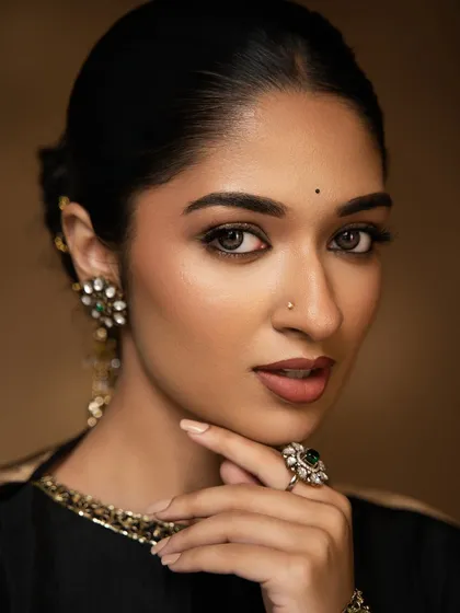 This is my signature soft glam look, perfect for a reception or sangeet. I used airbrush makeup to achieve this dewy, skin-like finish that feels light and looks stunning in photos. The look is completed with a shimmery gold and brown eye and a perfect nude lip.