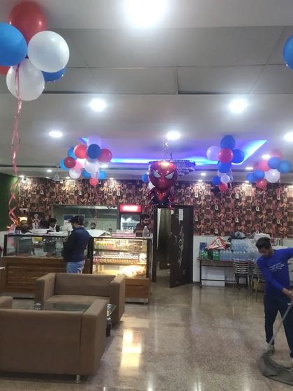 This wide shot shows how I use ceiling balloon bunches and a central hanging foil balloon to carry the party theme throughout the entire restaurant interior.