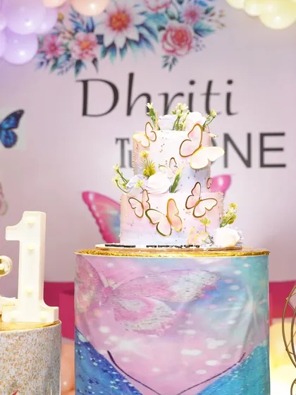 A close-up of the beautiful tiered cake from a fairy tale butterfly party. I can coordinate with bakers to ensure the cake matches the decor perfectly.