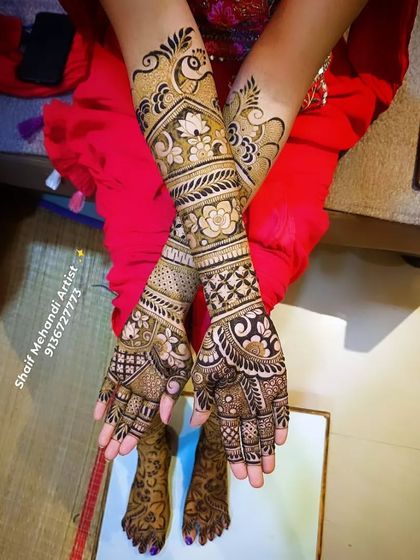 A beautiful bridal design featuring a prominent peacock on the forearm, surrounded by floral and geometric patterns.