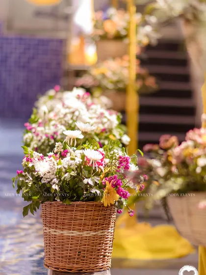 A close-up of the beautiful floral arrangements in wicker baskets, placed along the edge of the pool.