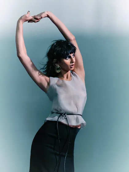 Another graceful, arms-up pose that showcases the fluidity of the garment and the model's movement. The entire series is a study in elegance and motion.