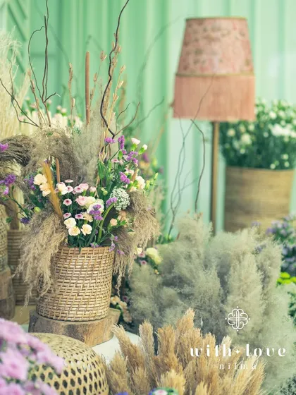 A corner of 'The Conservatory' filled with wicker baskets of dried grasses and flowers, adding texture and a rustic touch to the modern design.