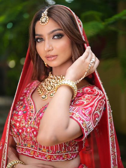 A complete bridal look featuring a heavy, gold-plated Kundan necklace, haath phool, and maang tikka, all available for rent.