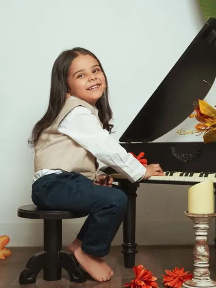 A pre-mundan photoshoot with a vintage vibe. The mini piano and autumn-toned decor create a classic and handsome portrait.