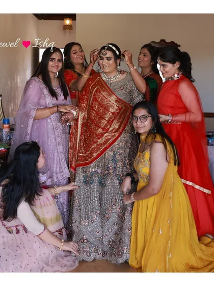 A candid moment showing the bride surrounded by her friends. It's a beautiful picture of joy and friendship, with the bride looking stunning in her full attire.