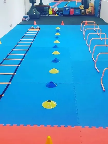 The mats are set for a conditioning session. We use agility ladders, cones, and hurdles to improve footwork, speed, and coordination, which are crucial for grappling.