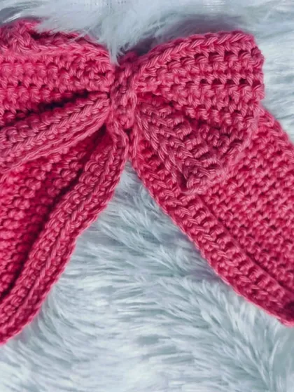 This big, bold pink crochet bow is perfect for anyone who loves to make a statement. It's handcrafted with a sturdy stitch to hold its shape while still being soft and lightweight.