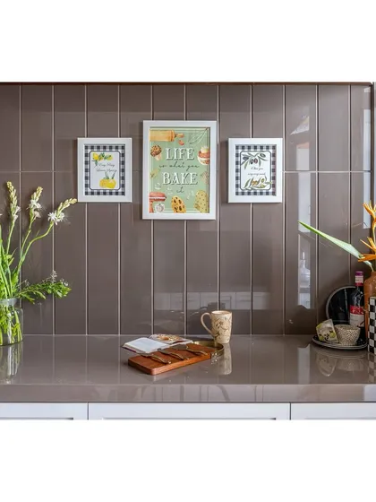 A close-up of the kitchen counter, featuring charming, framed art against a tiled backsplash. We believe in adding personal touches to make every corner of the home feel special.