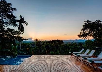 The pool deck at sunset, offering breathtaking views over the paddy fields and rainforest hills.