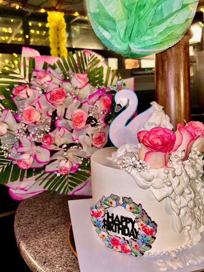 A beautiful shot of my swan cake next to a matching bouquet of pink roses, showing how a cake can be the perfect complement to your event's decor.