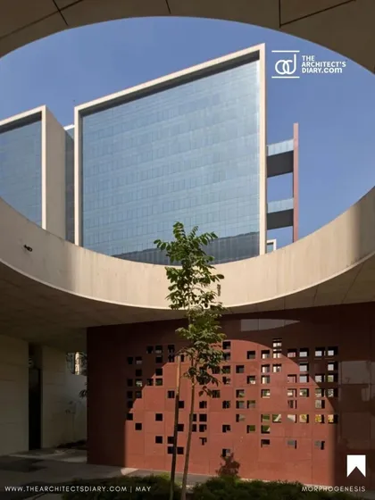 A view through a circular opening at the Surat Diamond Bourse frames one of the glass-clad office towers. This compositional technique creates visual interest and highlights the layered nature of the architectural design.